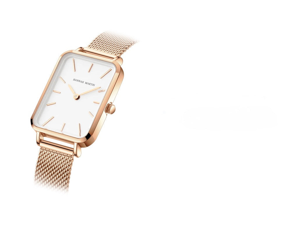 Rose gold watch with a white face on a white background
